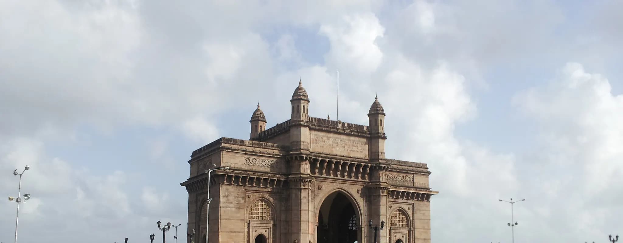 The Gateway of India overlooks a busy waterfront plaza in Mumbai.