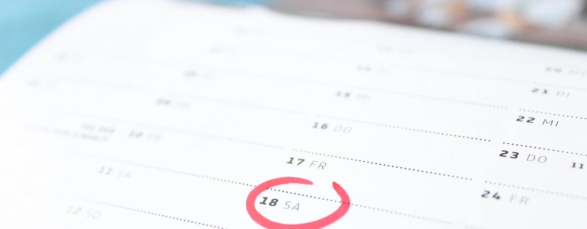Close-up of a paper calendar with one date circled in red.